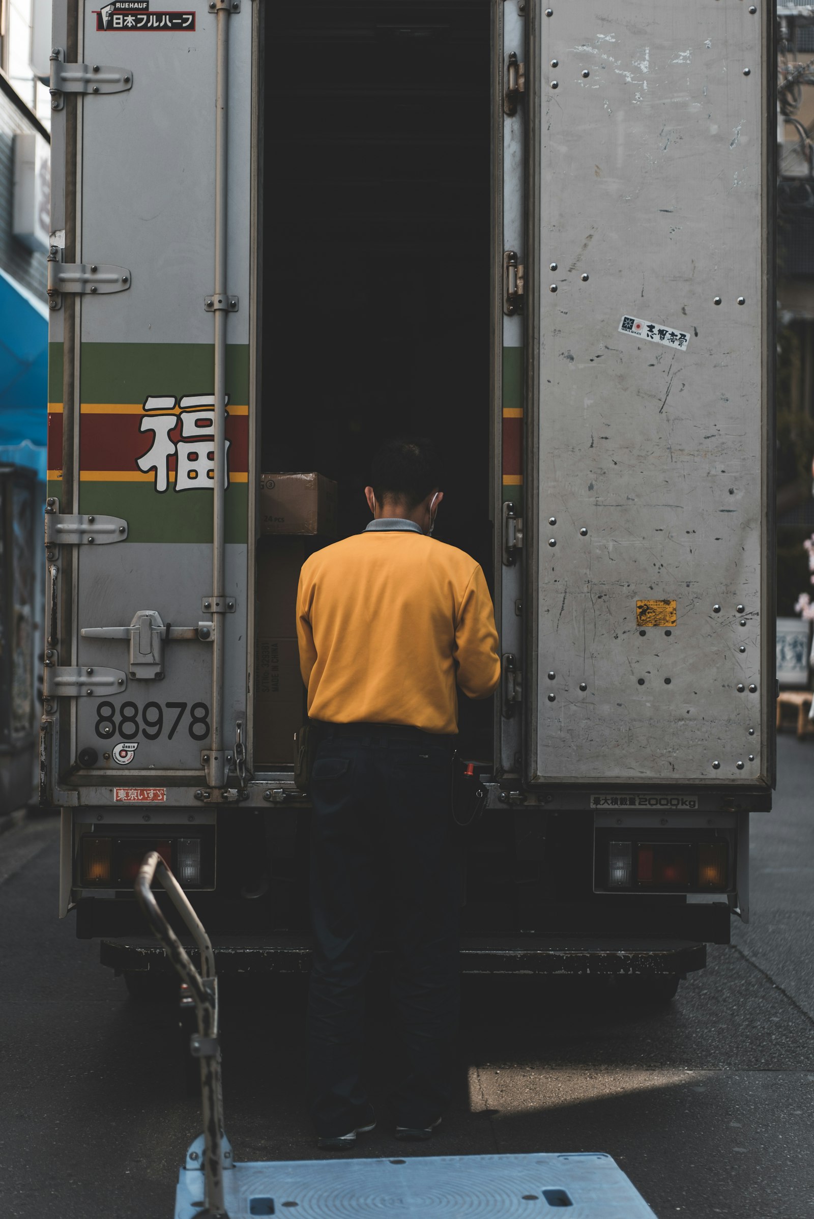 日本の物流現場でトラックに荷物を積み込む作業員